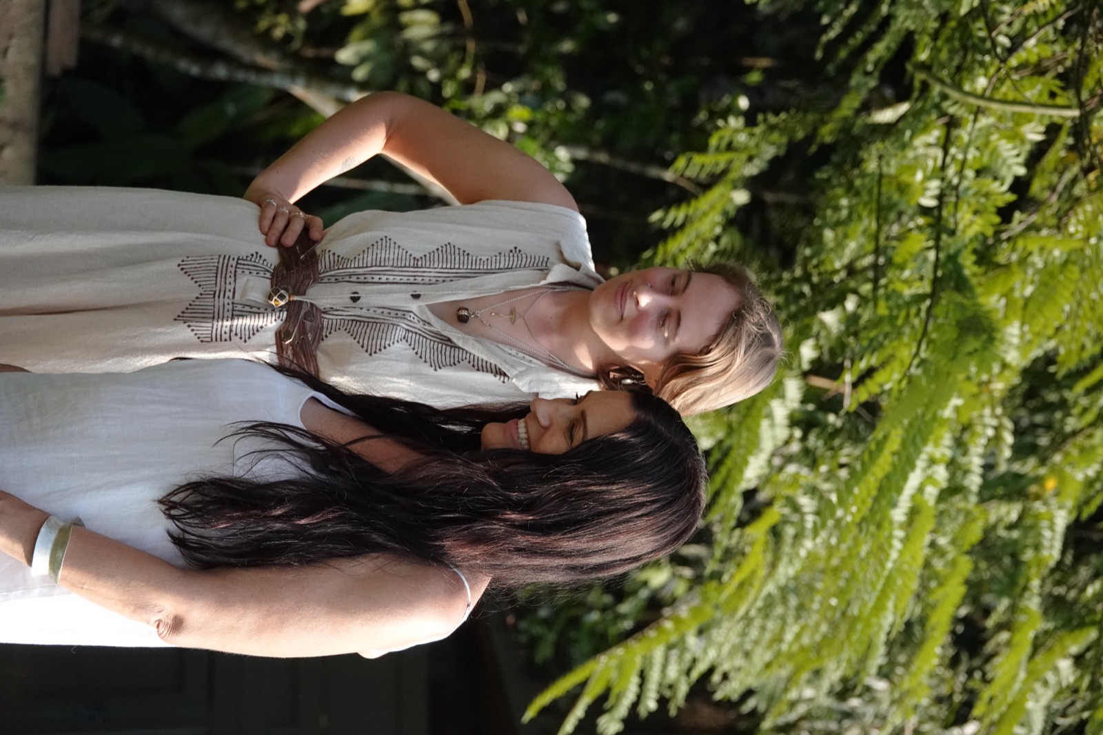Two friends pause together beneath the ferns