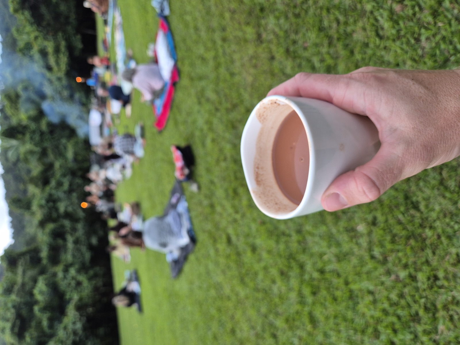 A cup of ceremonial cacao, the circle gathering behind