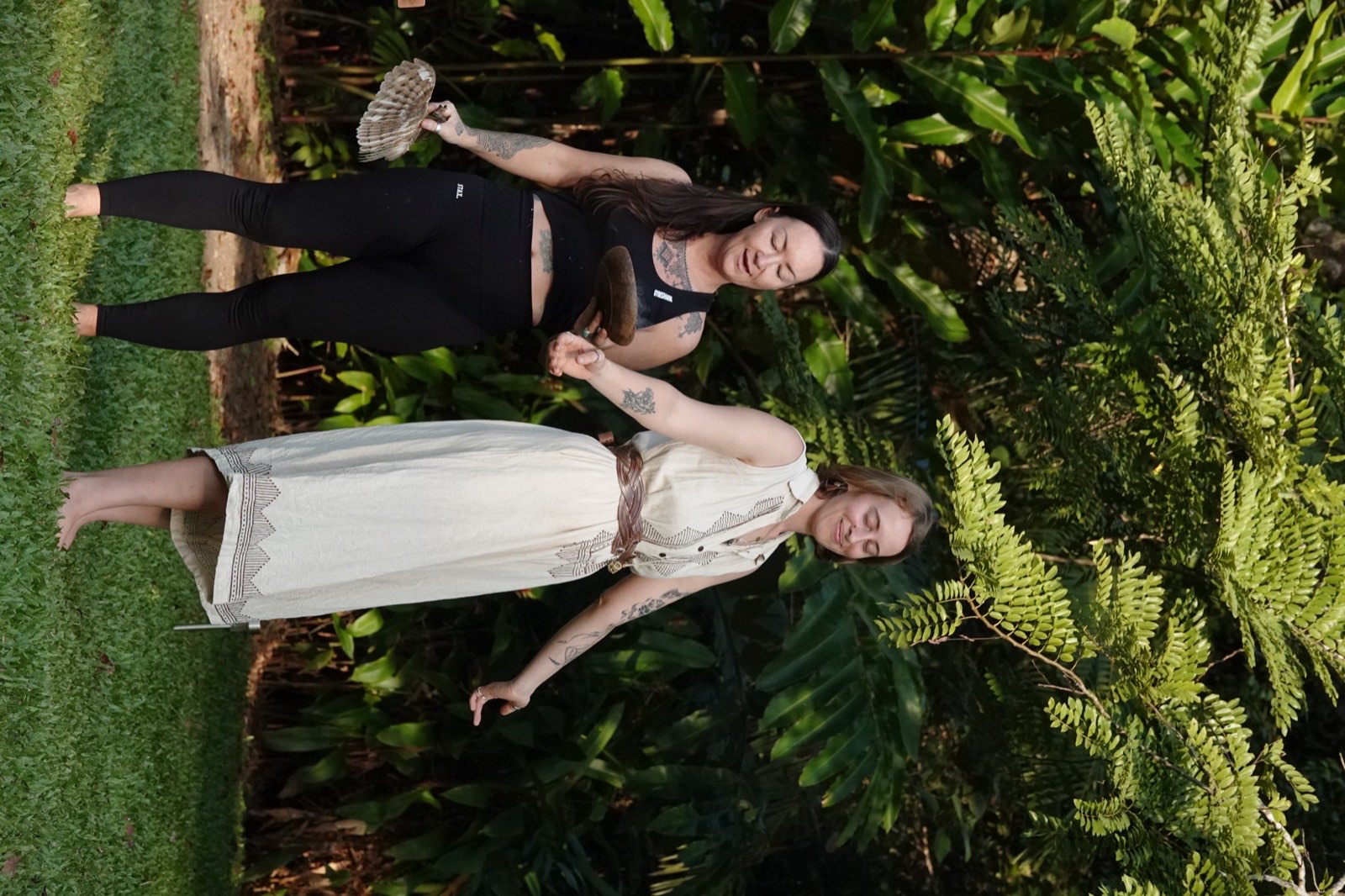 Two facilitators walk the space with sage and feathers