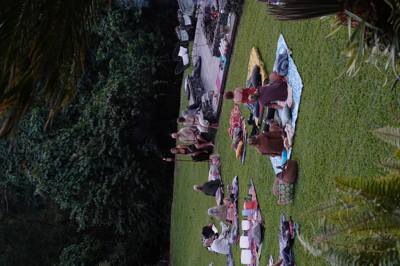 The circle settles onto mats as the light fades
